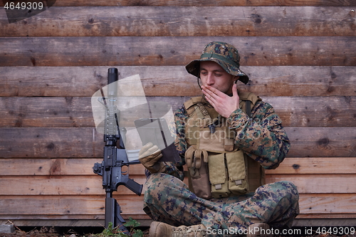 Image of soldier using tablet computer in military camp