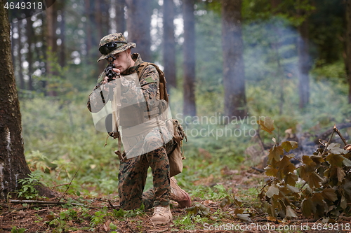 Image of soldier in action aiming  on weapon  laser sight optics