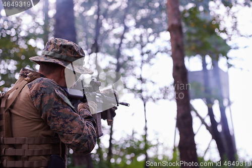 Image of soldier in action aiming  on weapon  laser sight optics