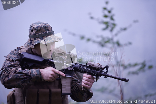 Image of soldier in action aiming  on weapon  laser sight optics