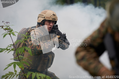 Image of soldier in action aiming  on weapon  laser sight optics