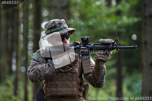 Image of soldier in action aiming  on weapon  laser sight optics