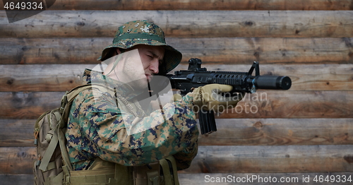 Image of soldier in action aiming  on weapon  laser sight optics