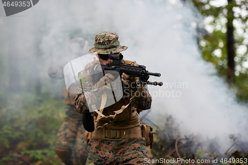 Image of soldier in action aiming  on weapon  laser sight optics