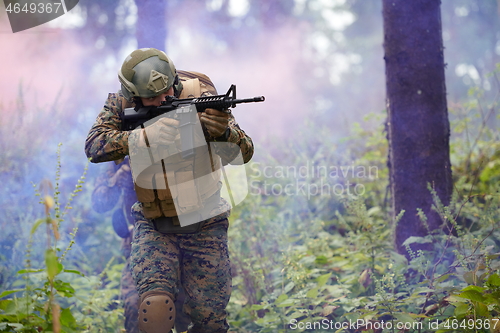 Image of soldier in action aiming  on weapon  laser sight optics