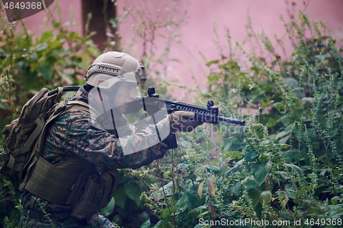 Image of soldier in action aiming  on weapon  laser sight optics