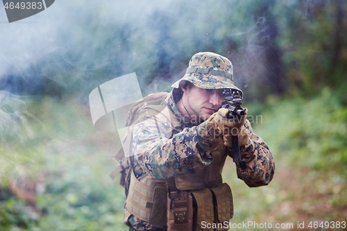 Image of soldier in action aiming  on weapon  laser sight optics