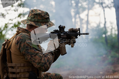 Image of soldier in action aiming  on weapon  laser sight optics