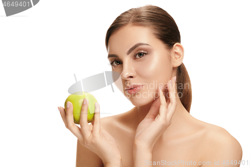 Image of portrait of attractive caucasian smiling woman isolated on white studio shot eating green apple