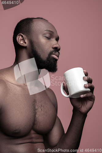 Image of African man with cup of tea, isolated on pink background