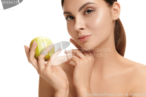 Image of portrait of attractive caucasian smiling woman isolated on white studio shot eating green apple