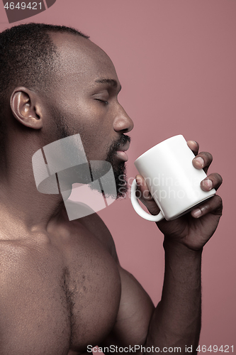 Image of African man with cup of tea, isolated on pink background