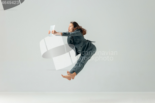 Image of Happy business woman dancing and smiling isolated over white.