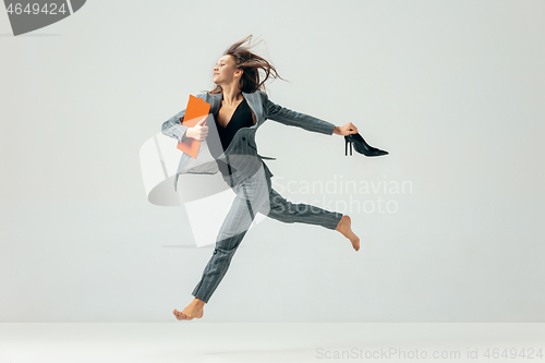 Image of Happy business woman dancing and smiling isolated over white.