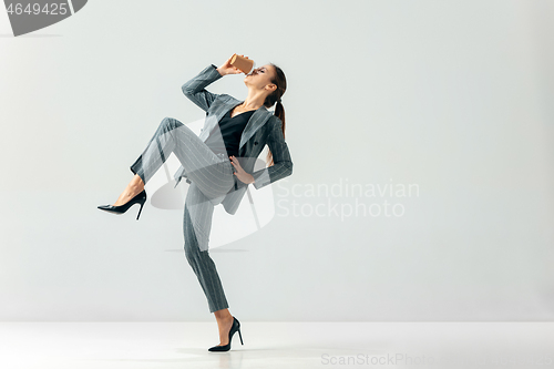 Image of Happy business woman dancing and smiling isolated over white.