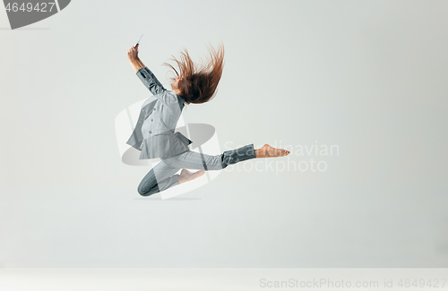 Image of Happy business woman dancing and smiling isolated over white.