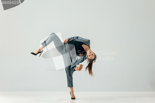 Image of Happy business woman dancing and smiling isolated over white.