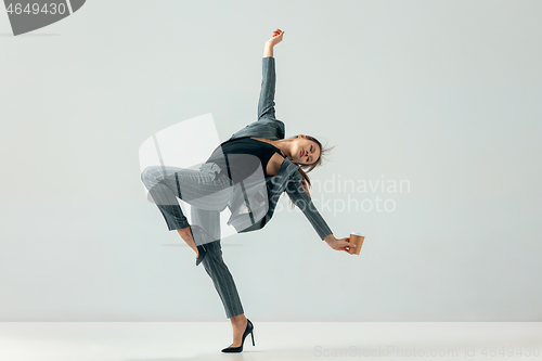 Image of Happy business woman dancing and smiling isolated over white.