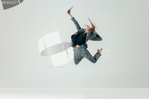 Image of Happy business woman dancing and smiling isolated over white.