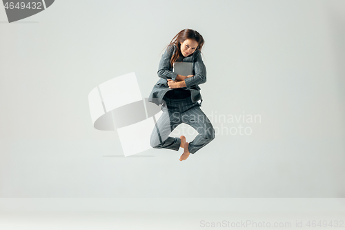 Image of Happy business woman dancing and smiling isolated over white.