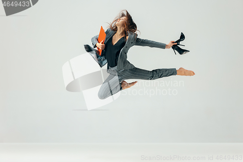 Image of Happy business woman dancing and smiling isolated over white.