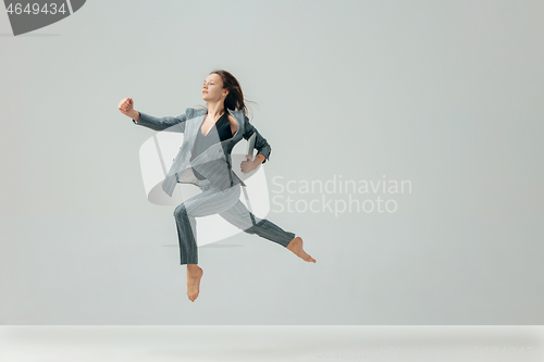 Image of Happy business woman dancing and smiling isolated over white.