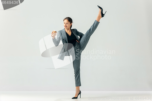 Image of Happy business woman dancing and smiling isolated over white.