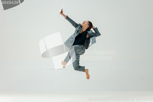 Image of Happy business woman dancing and smiling isolated over white.
