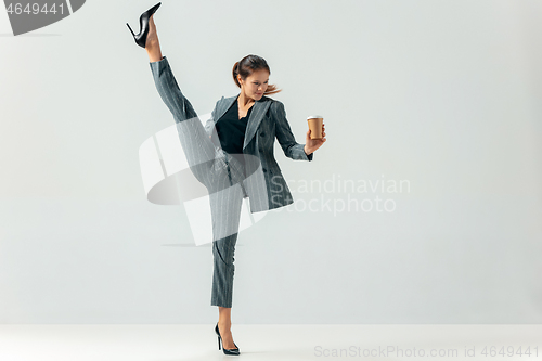 Image of Happy business woman dancing and smiling isolated over white.