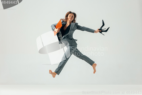 Image of Happy business woman dancing and smiling isolated over white.