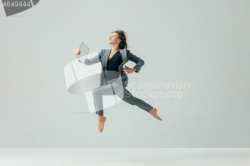 Image of Happy business woman dancing and smiling isolated over white.