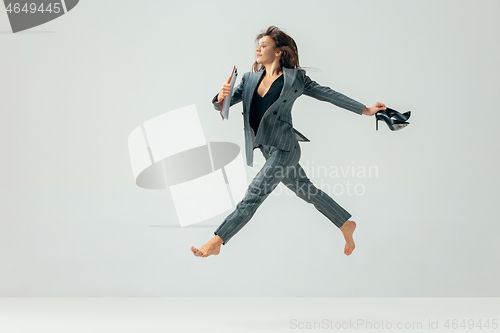 Image of Happy business woman dancing and smiling isolated over white.