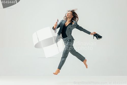 Image of Happy business woman dancing and smiling isolated over white.