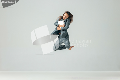 Image of Happy business woman dancing and smiling isolated over white.
