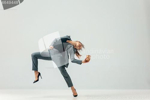 Image of Happy business woman dancing and smiling isolated over white.