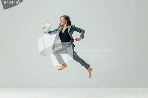 Image of Happy business woman dancing and smiling isolated over white.