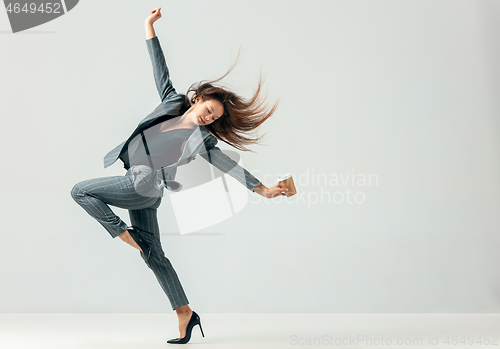 Image of Happy business woman dancing and smiling isolated over white.
