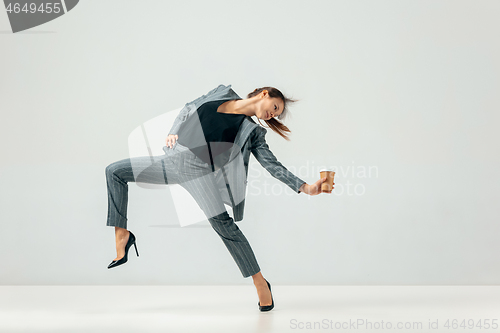 Image of Happy business woman dancing and smiling isolated over white.