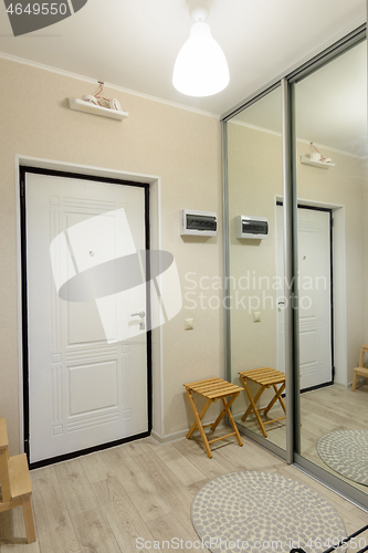 Image of Hallway interior, large fitted wardrobe with large mirrors on the doors, entrance metal door