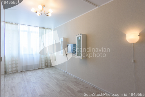 Image of Fragment of the interior of the room, curtained windows and a wall with a TV and hanging cabinets