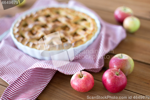 Image of apple pie in baking mold on wooden table