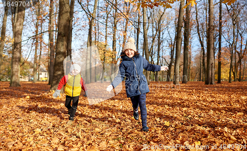 Image of happy children running at autumn park