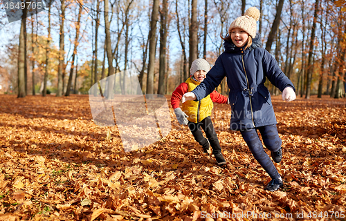 Image of happy children running at autumn park