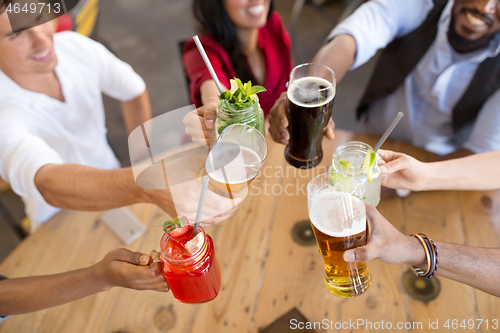 Image of friends clinking glasses at bar or restaurant