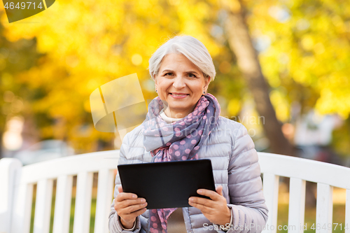 Image of senior woman with tablet pc at summer park