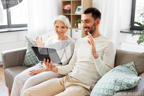 Image of old mother and adult son with tablet pc at home