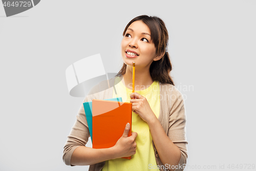Image of asian student woman with books and pencil