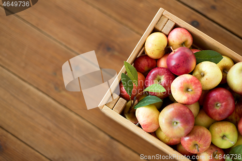 Image of ripe apples in wooden box on table