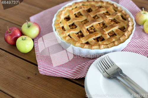 Image of apple pie in baking mold on wooden table