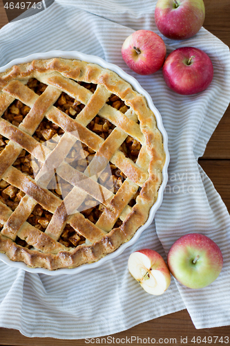 Image of apple pie in baking mold on wooden table